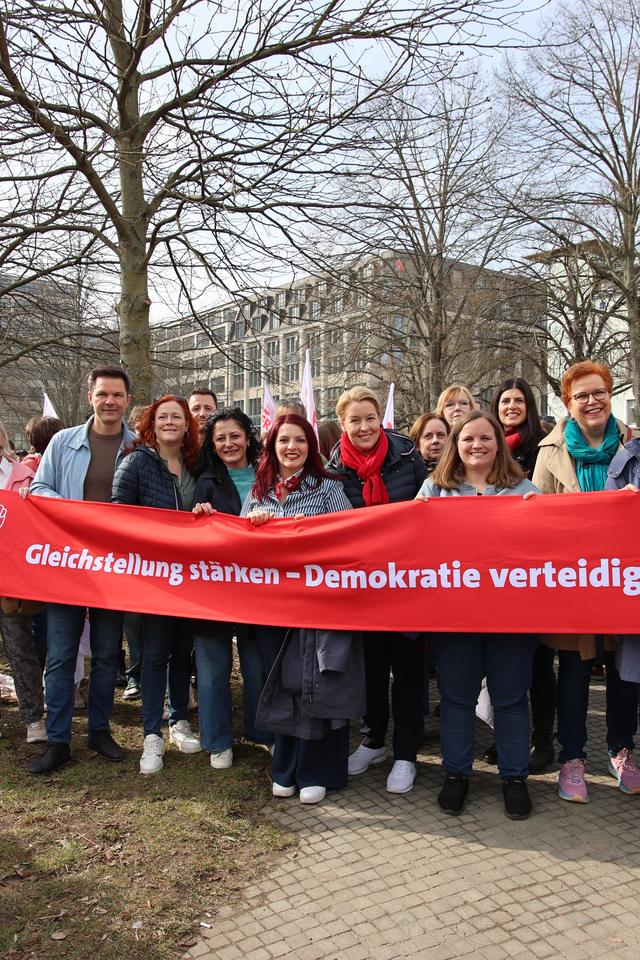 Demonstrierende hinter einem Banner mit der Aufschrift „Gleichstellung stärken – Demokratie verteidigen“