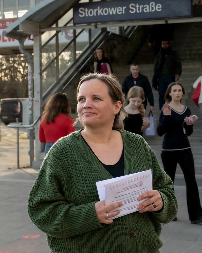 Marie Scharfenberg mit Flyern am Infostand an der Storkower Straße